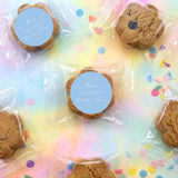 Clear plastic bag of bite-size chocolate chip cookies with round blue labels