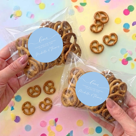 Personalised pretzel bag set with clear bags, brown pretzels, and blue round labels