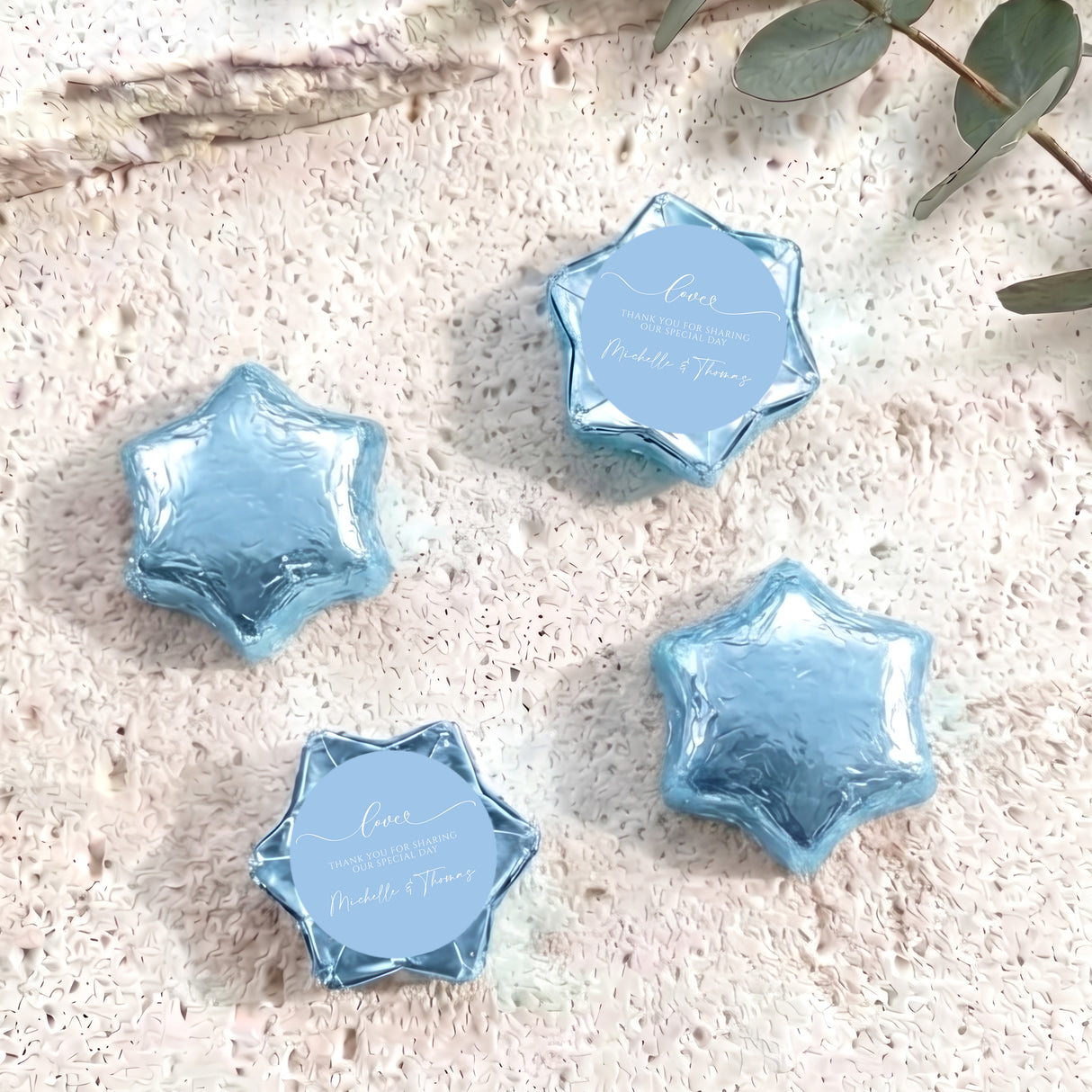 Blue foil-wrapped chocolate stars with round personalized label discs