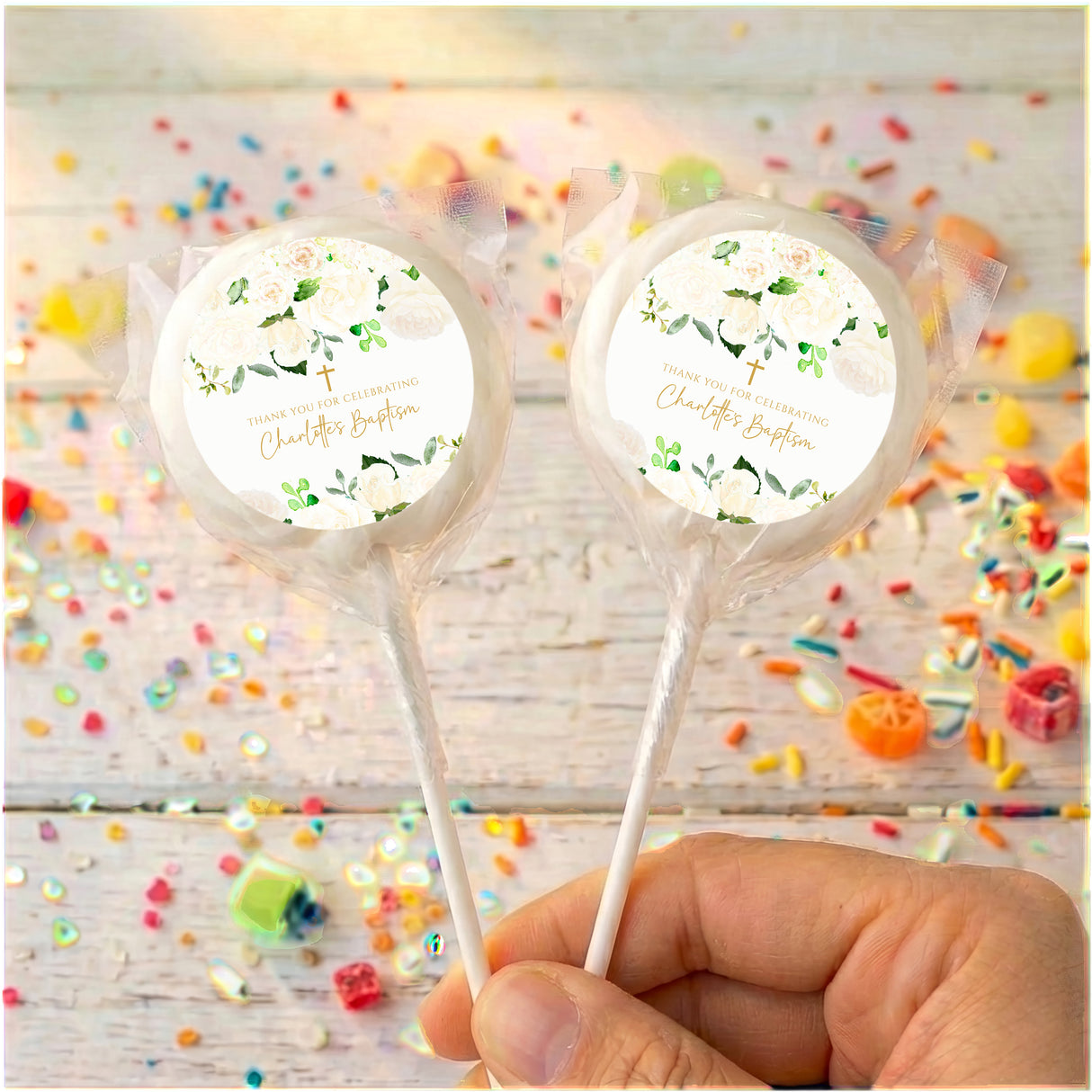 Personalised lollipop set with white labels and green floral print, held in hand