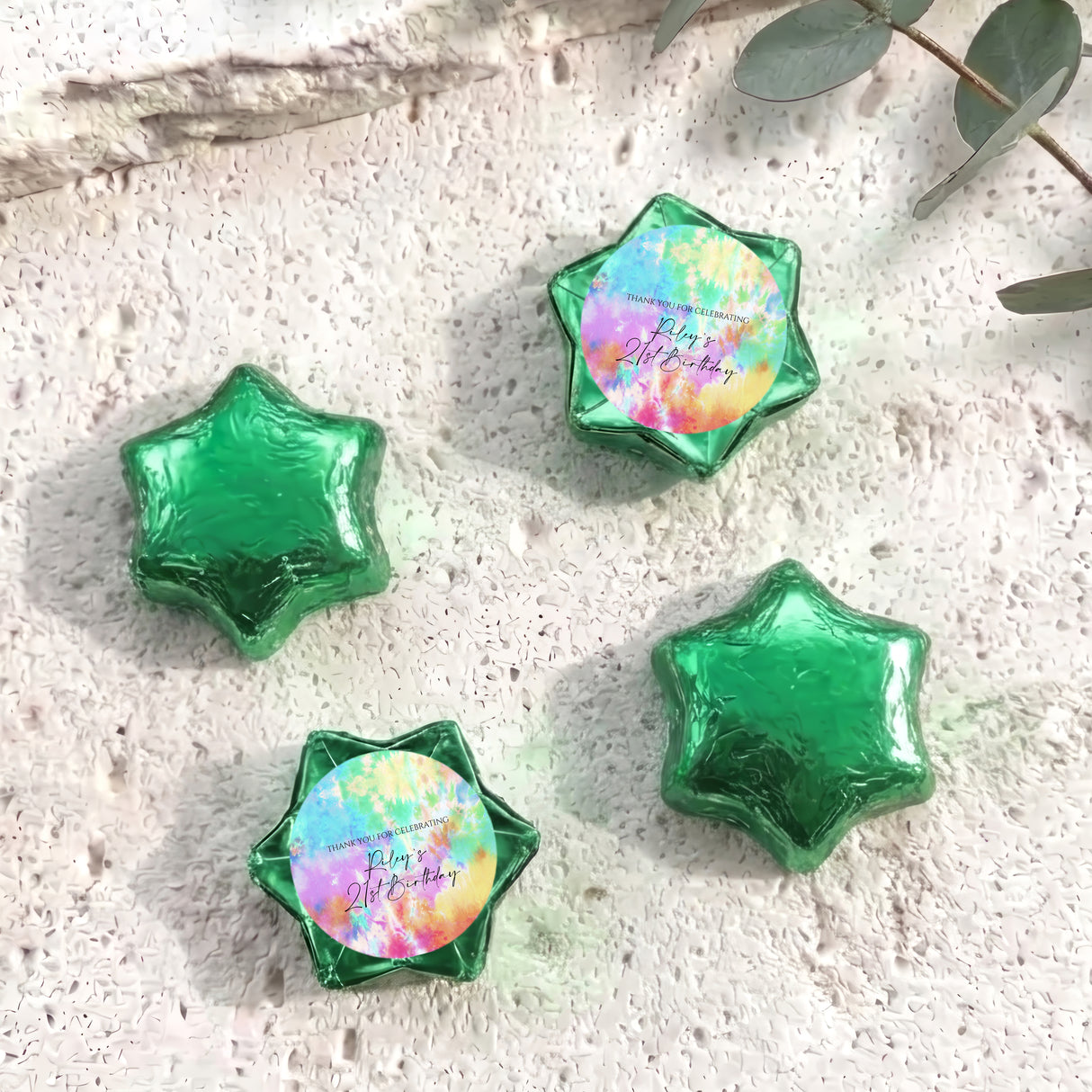Foil-covered star chocolates in green with one pastel tie-dye foil star