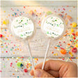 Personalised lollipops: cream round labels with green leaf cross, clear wrappers