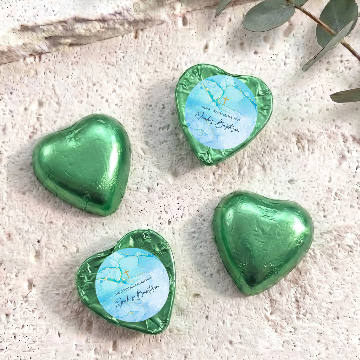 Green foil heart chocolates for baptism, with light blue label and gold cross print