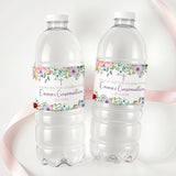 Printed bottle labels on two clear soda bottles with wildflower band and red accents