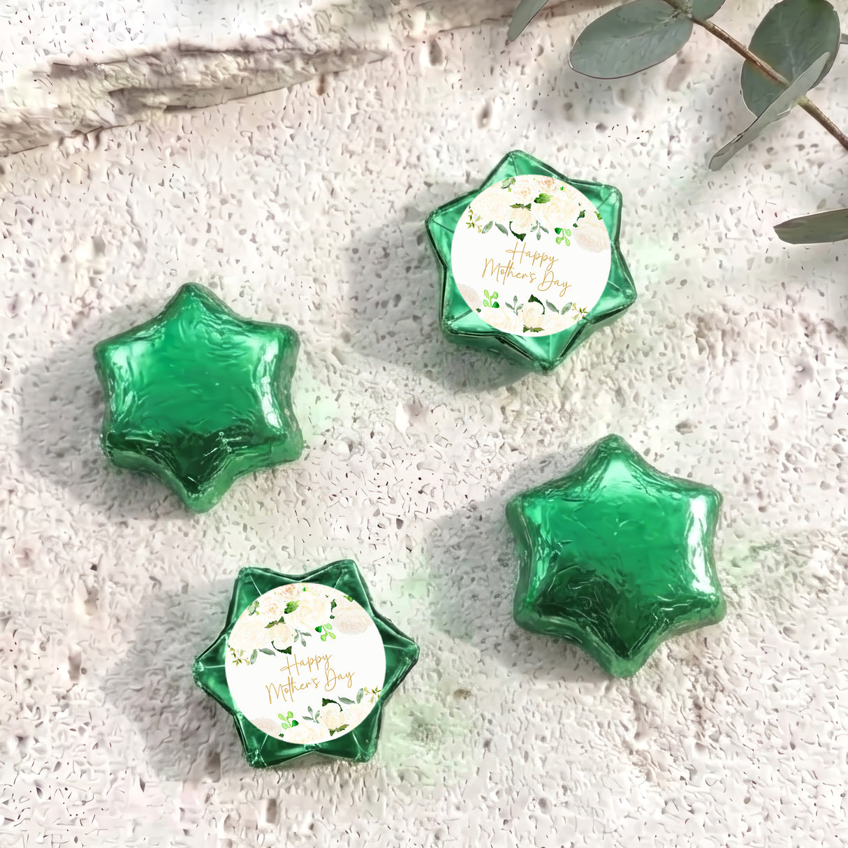 Green foil-covered chocolate stars with a round personalized label on each piece