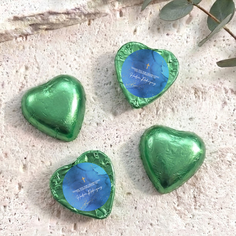 Foil-covered chocolate hearts, green with blue center labels and gold cross detail