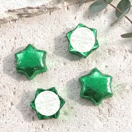 Green foil-covered chocolate stars with white center labels, arranged in a cluster.