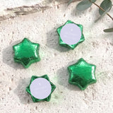 Green foil-covered chocolate stars with a small white cross on the wrapper center