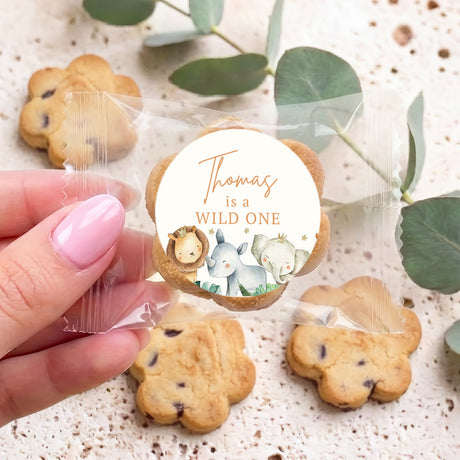 Bite-size chocolate chip cookies with round 'wild one' seal, in hand