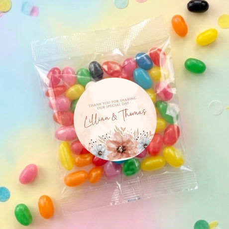 Jelly bean wedding favour bag with round floral label and thank-you text, filled with colorful sweets