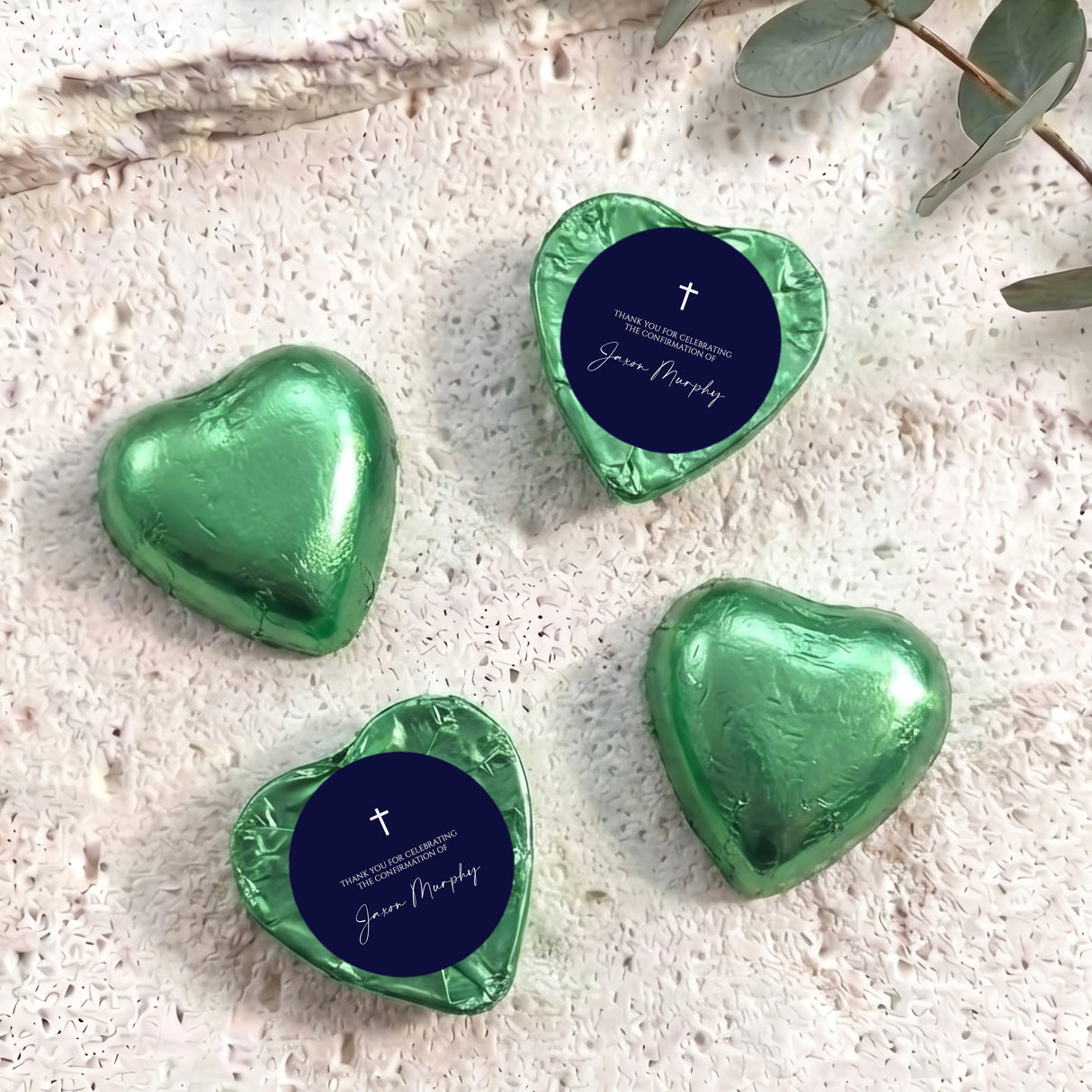 Foil heart chocolates with dark blue label and cross; green foil hearts