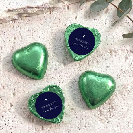 Foil heart chocolates with dark blue label and cross; green foil hearts