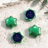 Foil-covered chocolate stars set with green wrappers and navy label with white cross