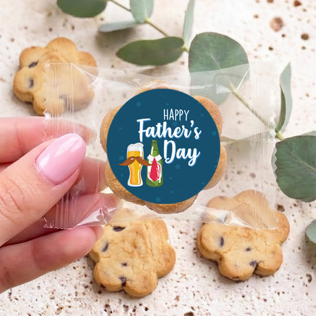 Hand holding a personalized Father's Day cookie in a clear wrapper with a dark blue sticker