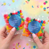 Two personalised jelly bean bags with blue round stickers and gold cross emblems