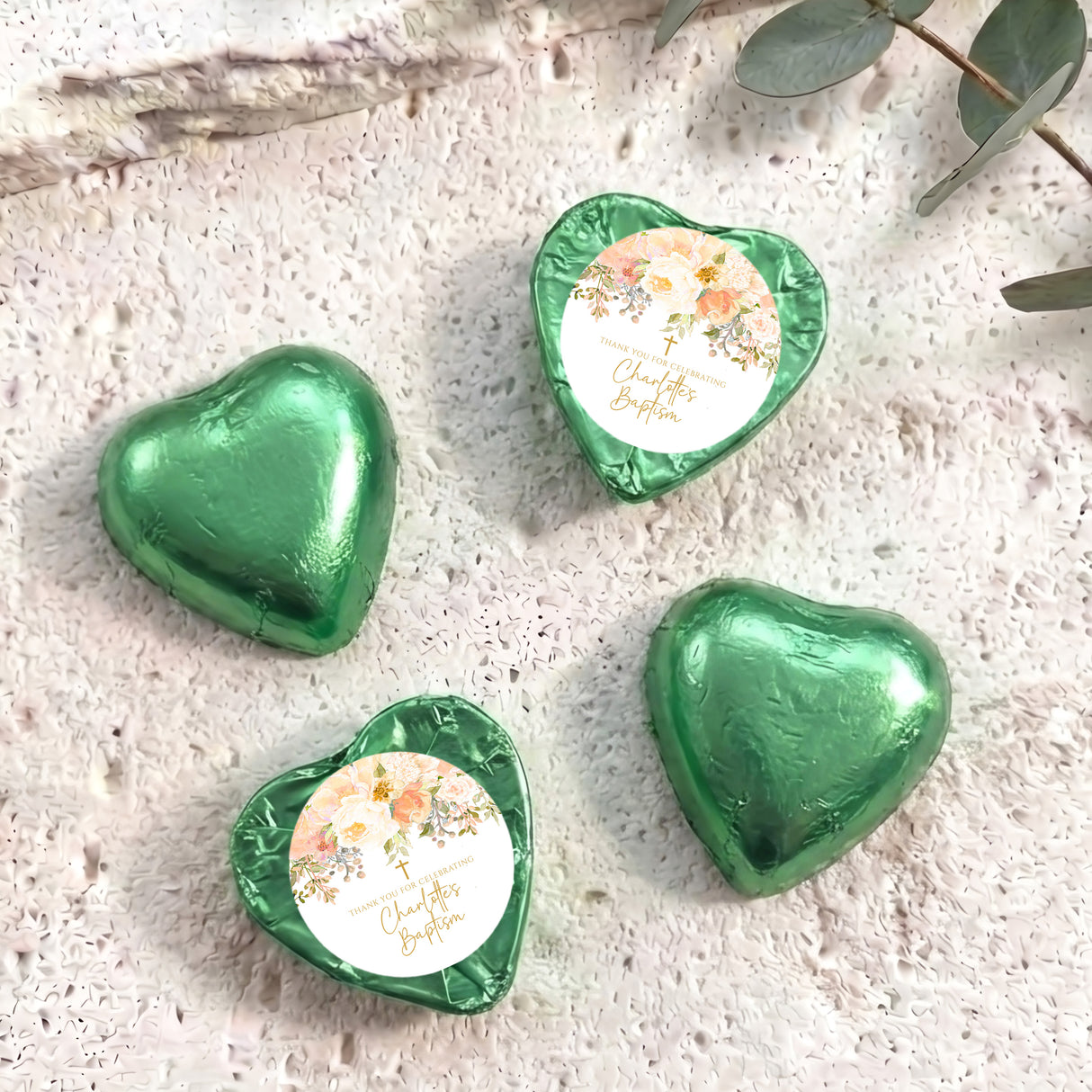 Green foil-covered chocolate hearts with floral paper center and gold-toned trim