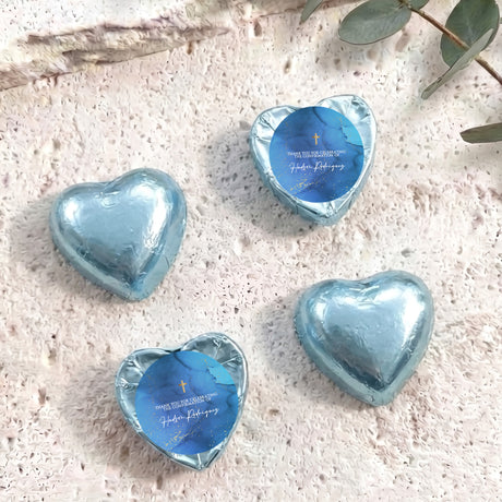 Foil-covered chocolate hearts, light blue, with blue center labels and gold cross detail