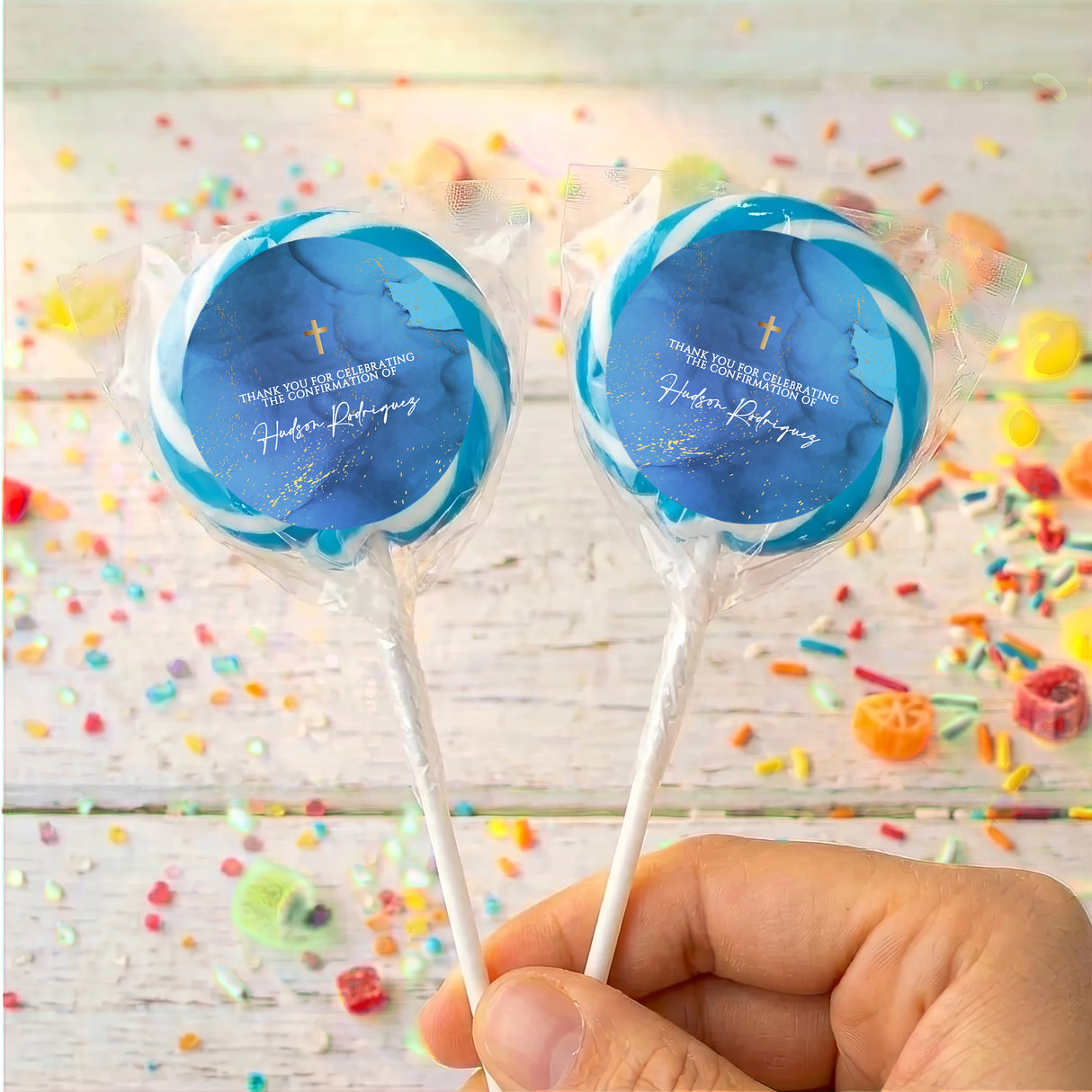 Confirmation lollipops with blue round labels, gold cross and personalized text, clear wrappers.