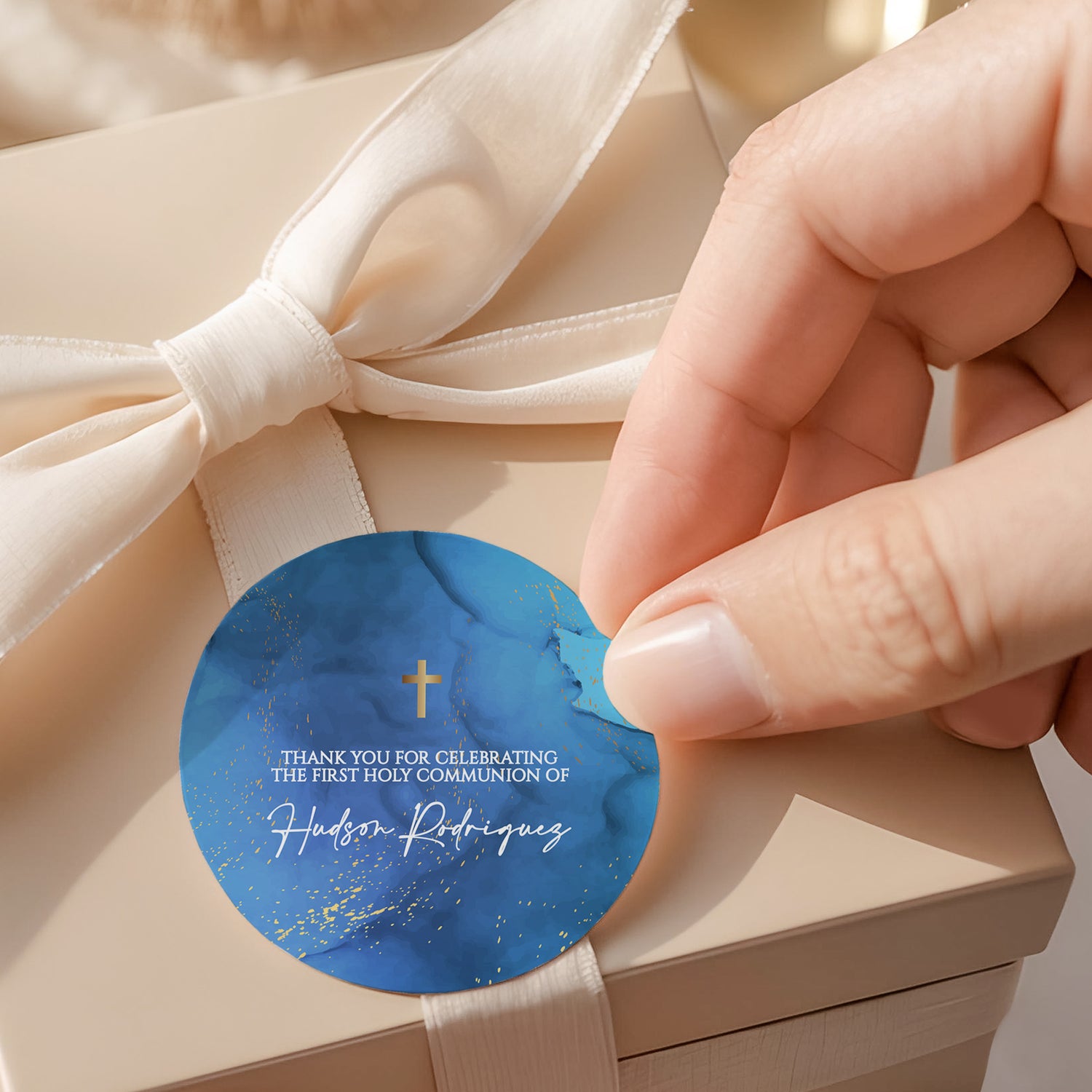 Round blue first communion thank-you label with gold cross and printed name text