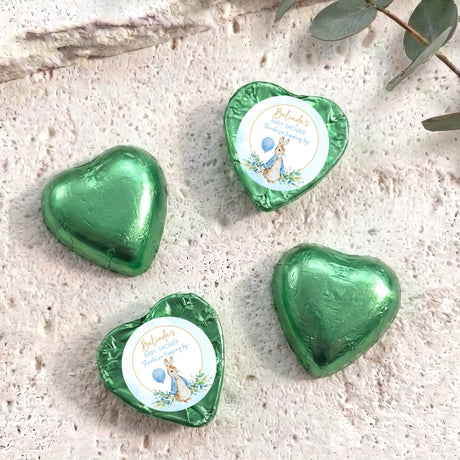 Green foil-covered chocolate hearts with baby shower label and bunny illustration