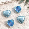Foil-covered chocolate hearts with blue wrappers and gold cross design