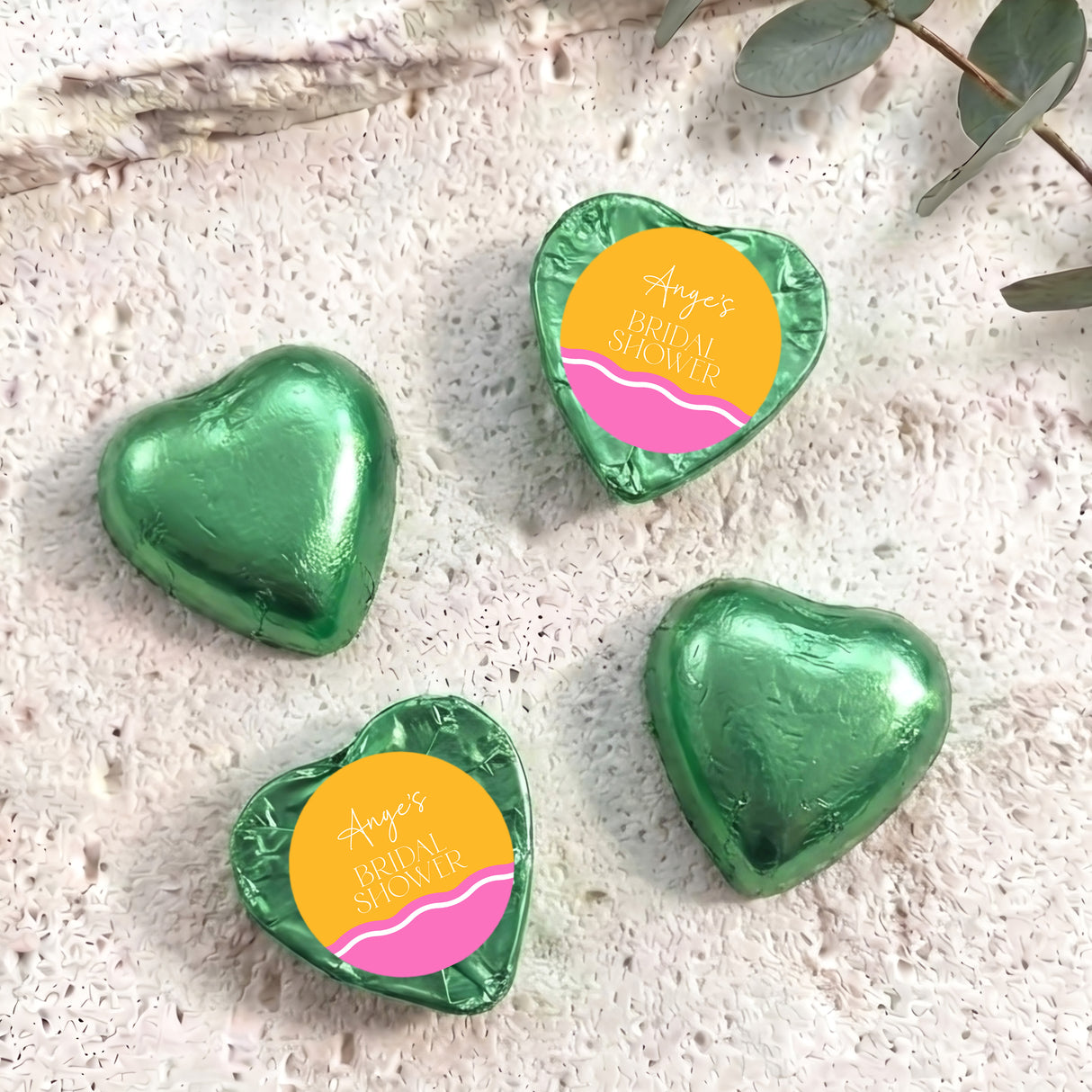 Green foil-covered chocolate heart chocolates with personalized label, heart shape.