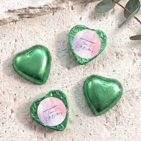 Green foil-covered heart chocolates with round personalised labels on top