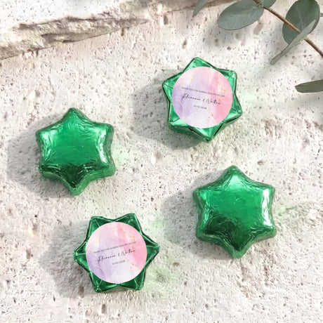 Green foil star chocolates with circular personalized label in star-shaped wrapper