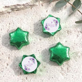 Green foil-covered chocolate stars with round confirmation label and purple floral cross