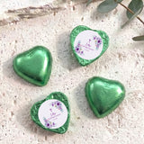 Foil-covered chocolate hearts with green finishes, floral cross message medallions