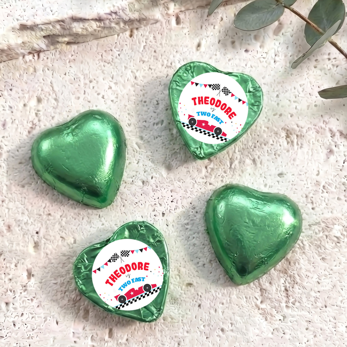 Green foil-covered chocolate heart with “THEODORE TWO FAST” label