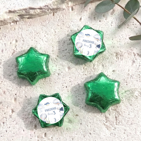 Green foil-covered chocolate stars with personalised card reading “Freddie”