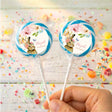 Personalised bunny floral lollipops with blue-bordered round labels, held in hand