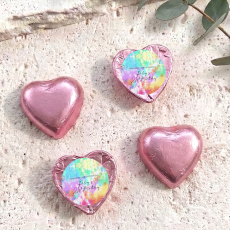 Pink foil heart chocolates with tie-dye personalized print; four hearts shown