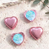 Pink foil heart chocolates for baptism, featuring blue label, gold cross and name