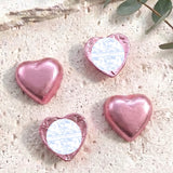 Pink foil-covered chocolate hearts with heart-shaped foil wrap and white label