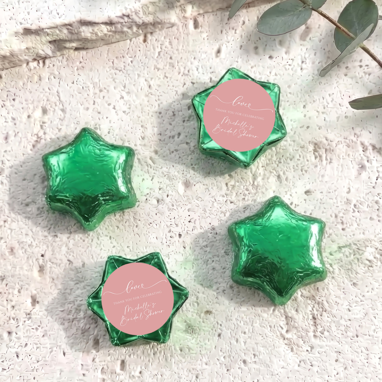Set of green foil-covered chocolate stars with a pink heart label