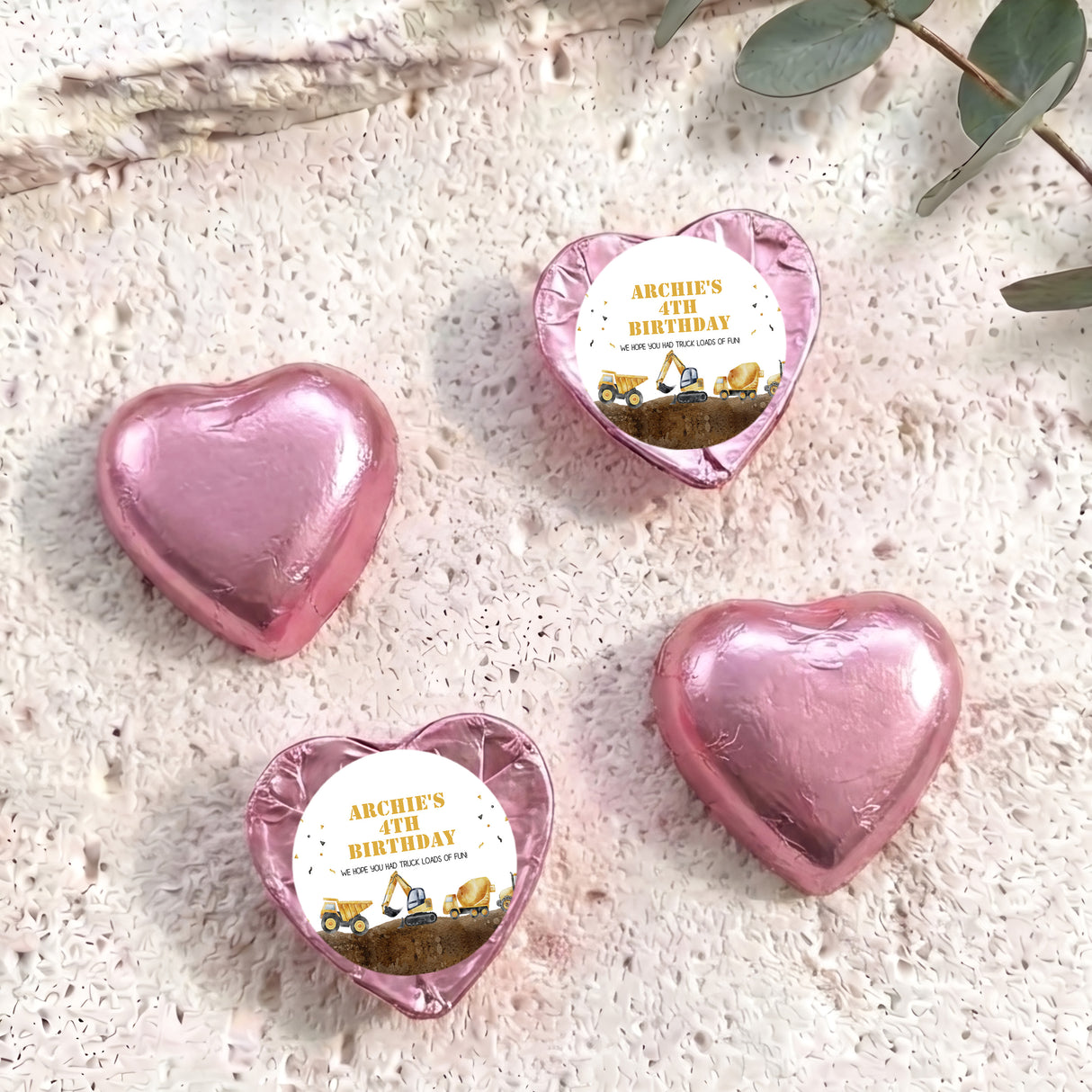 Foil-covered chocolate hearts in pink with birthday label featuring a construction truck