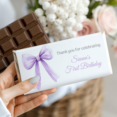 Custom chocolate bar gift wrapper with lilac bow and “First Birthday” text