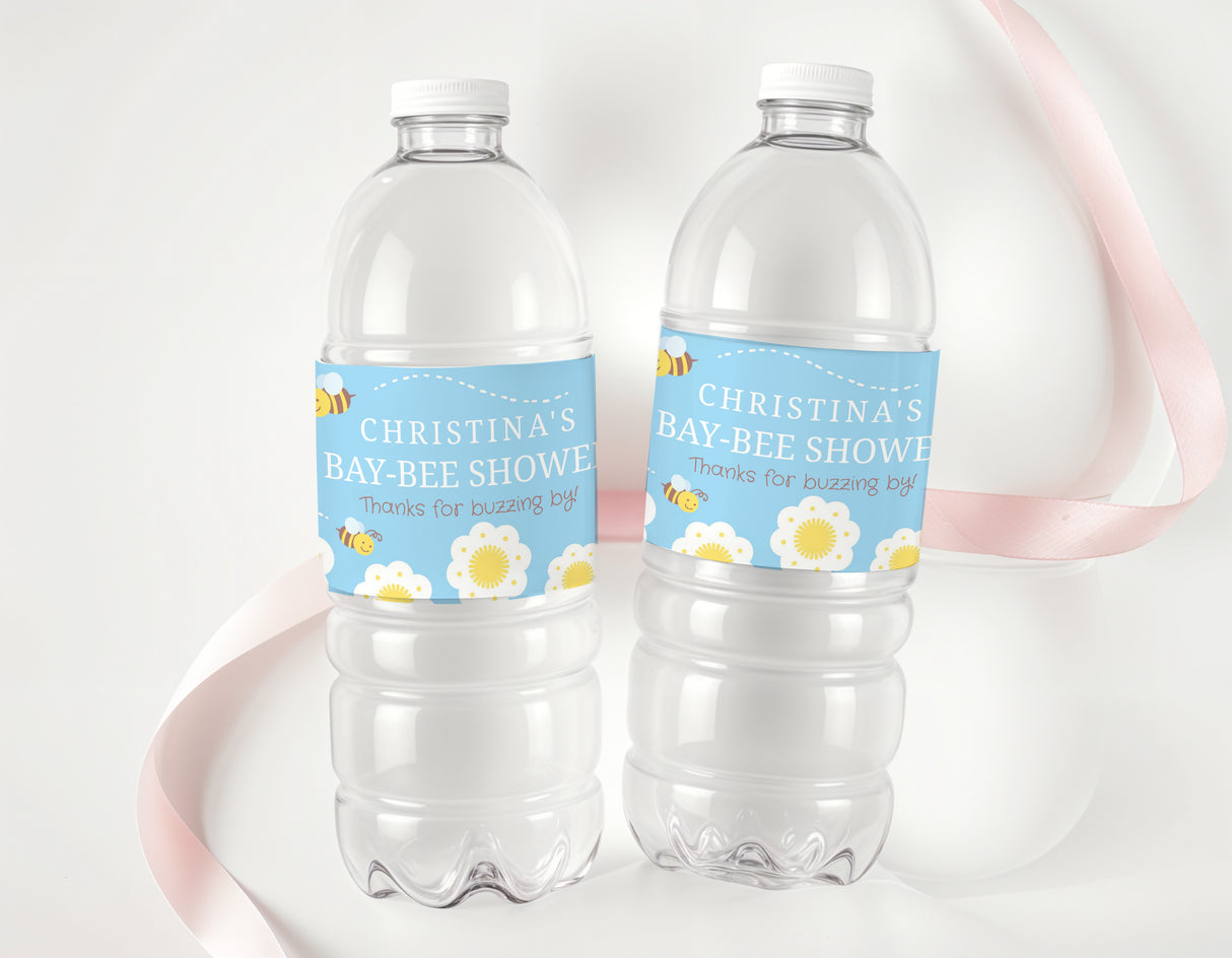 Two clear plastic water bottles with white caps, blue personalized bee shower labels