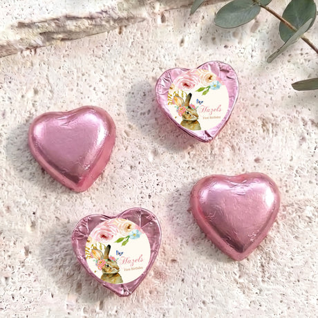 Pink foil-covered chocolate heart with decorative floral foil-wrapped center