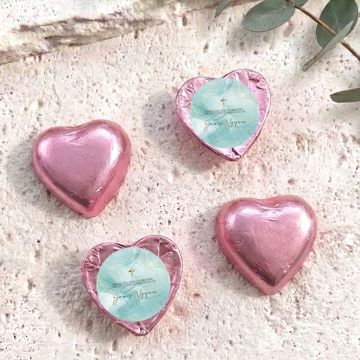 Pink foil heart chocolates with blue center label and gold cross