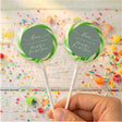 Personalised wrapped lollipops with round sage-green labels and green ribbon accents on sticks