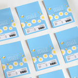 Blue DIY chocolate wrappers with bee flowers and “Amelia is Three”