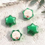 Foil-covered chocolate stars with green metallic wrap and floral thank-you label