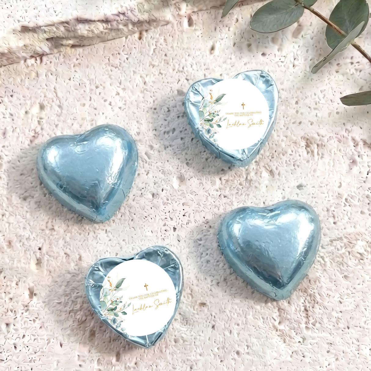 Light blue foil heart chocolates with baptism cross and floral label on white circle