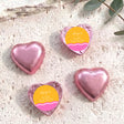Pink foil heart chocolates with “Ange’s Baby Shower” label, wavy pink-orange design