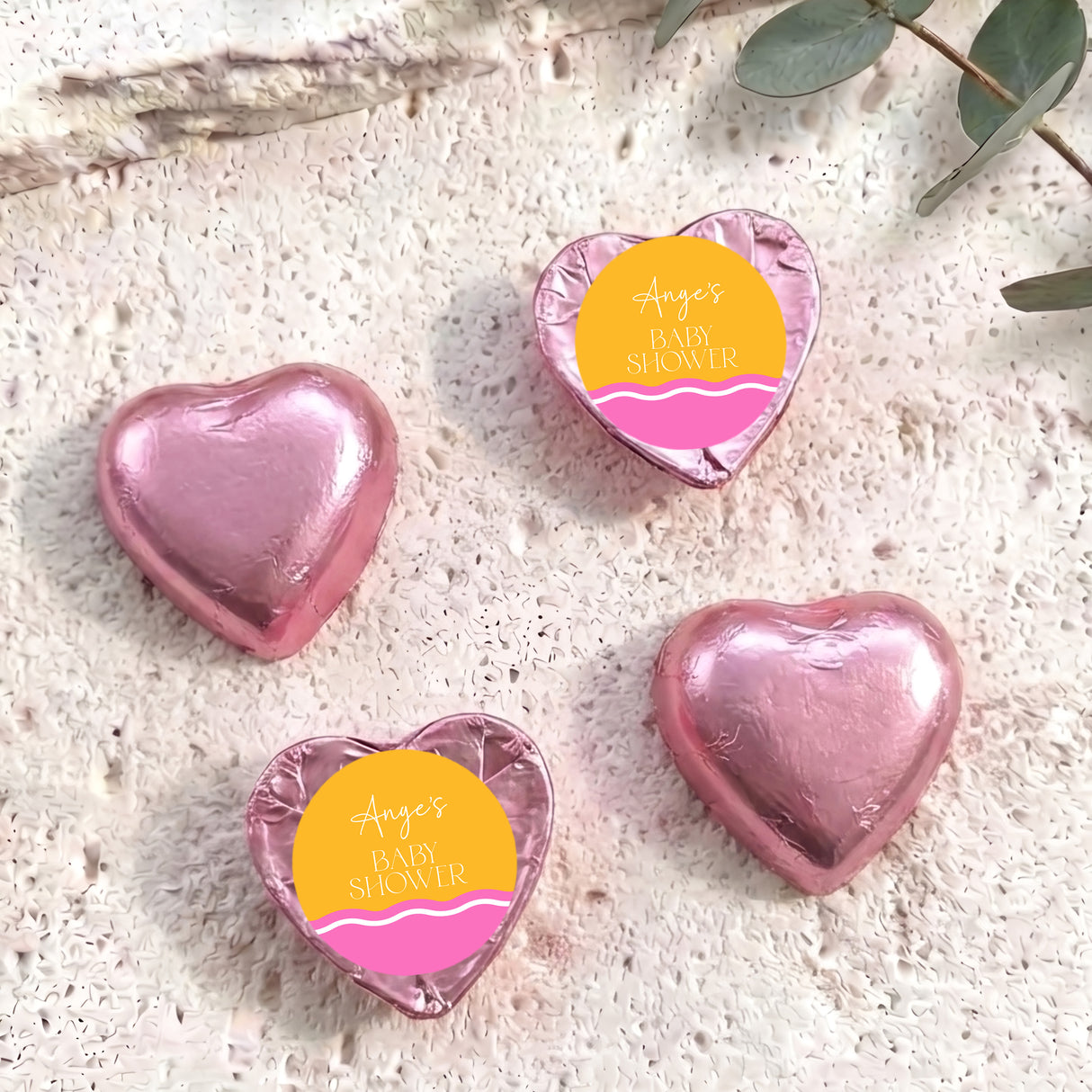 Pink foil heart chocolates with “Ange’s Baby Shower” label, wavy pink-orange design