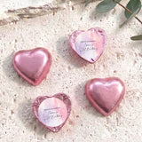 Foil-covered chocolate hearts, pink heart-shaped chocolates with a round label on top