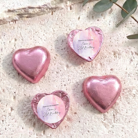 Foil-covered chocolate hearts, pink heart-shaped chocolates with a round label on top